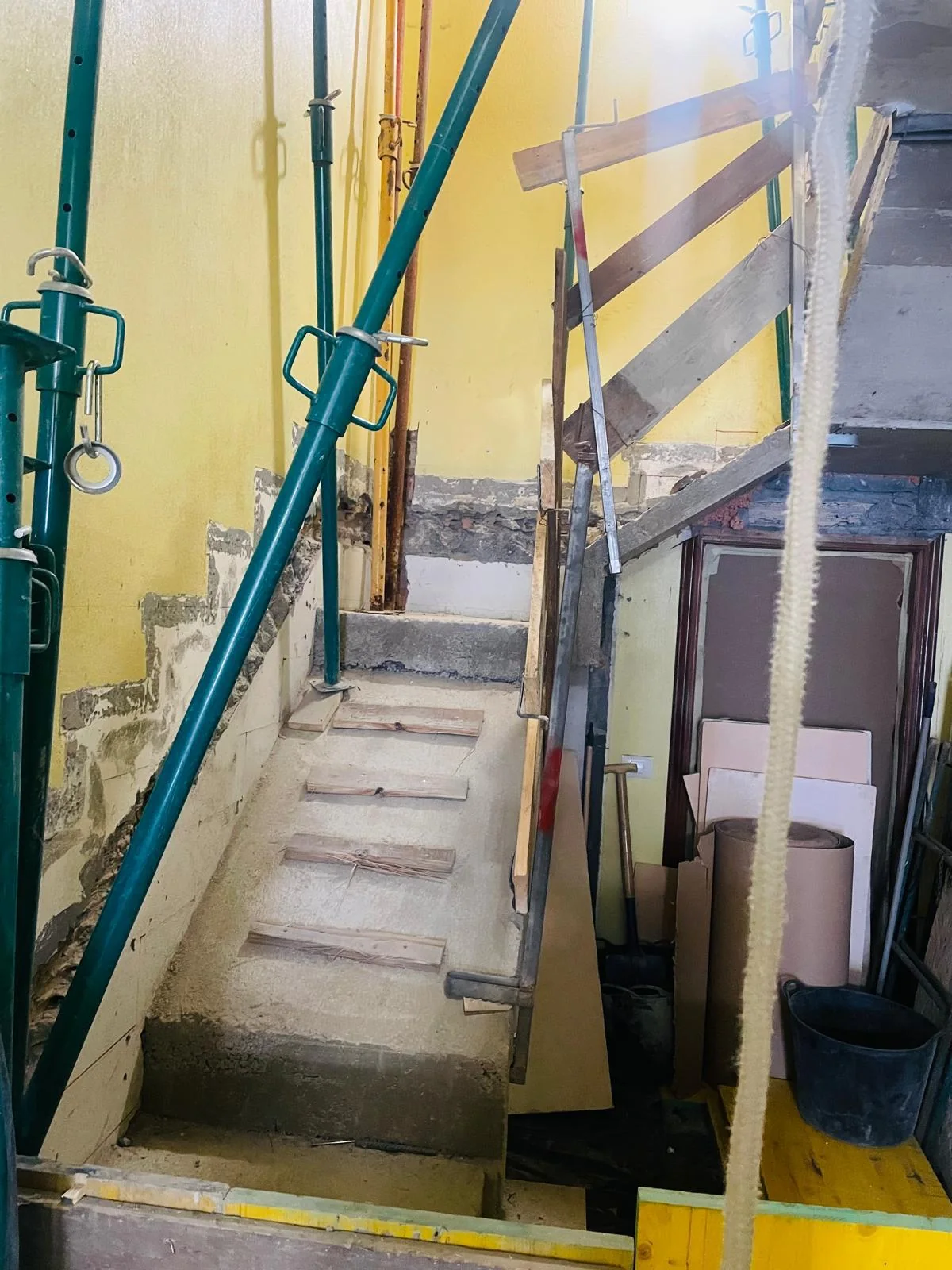 Encofrado de escalera de hormigón en un edificio, con puntales y apeos