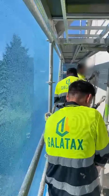 Equipo de Construcciones Galatax aplicando mortero en fachada desde el andamio