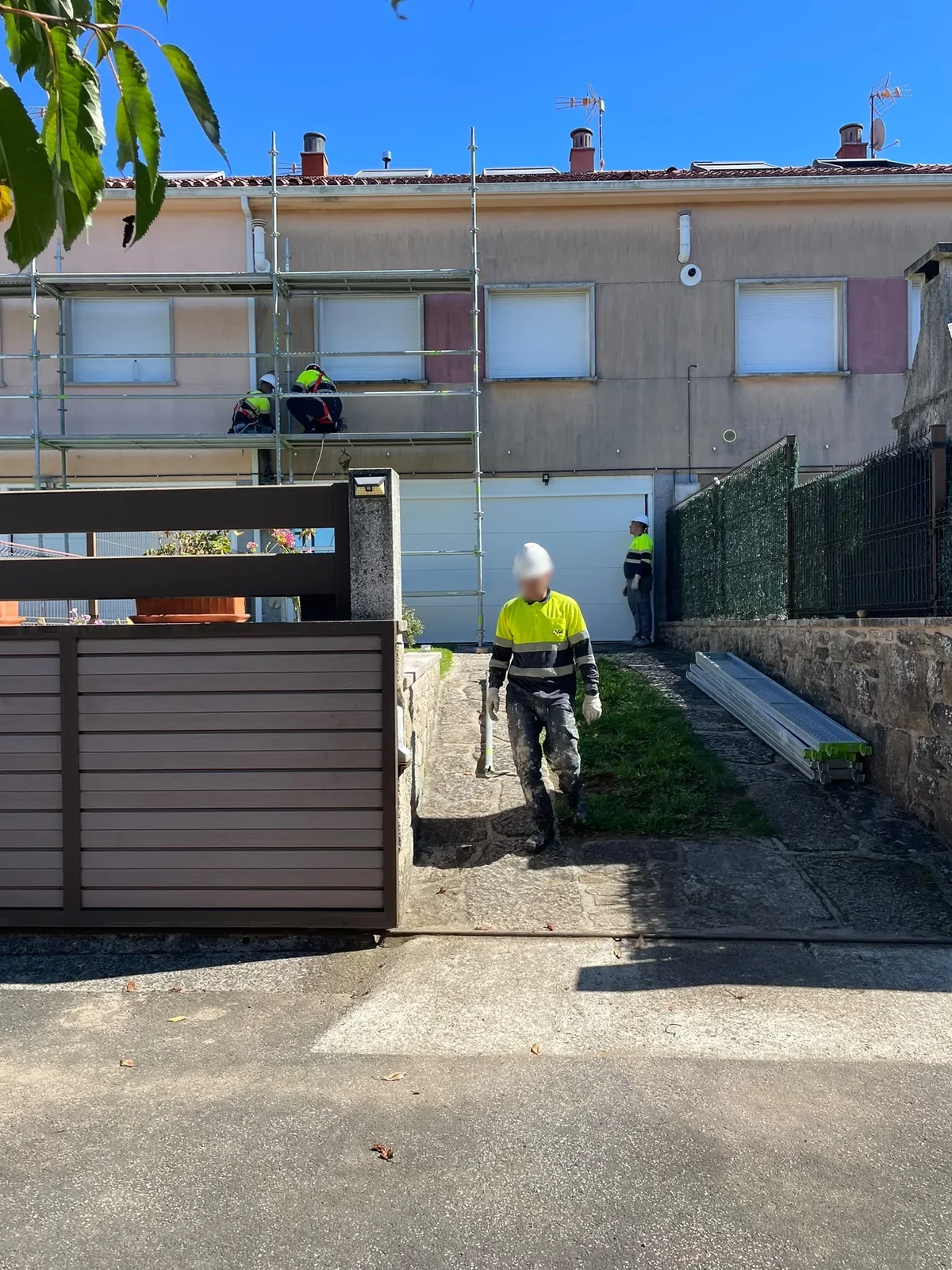 Rehabilitación de fachada en viviendas adosadas con andamio y protección